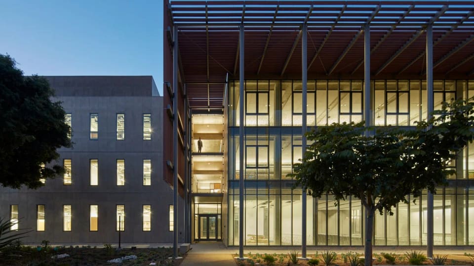 Henley Hall at UC Santa Barbara, photographed at dusk with its illuminated glass facade.