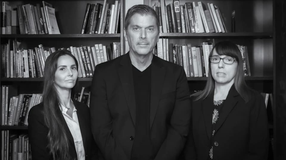 Three Chapman University researchers standing in front of bookshelves.