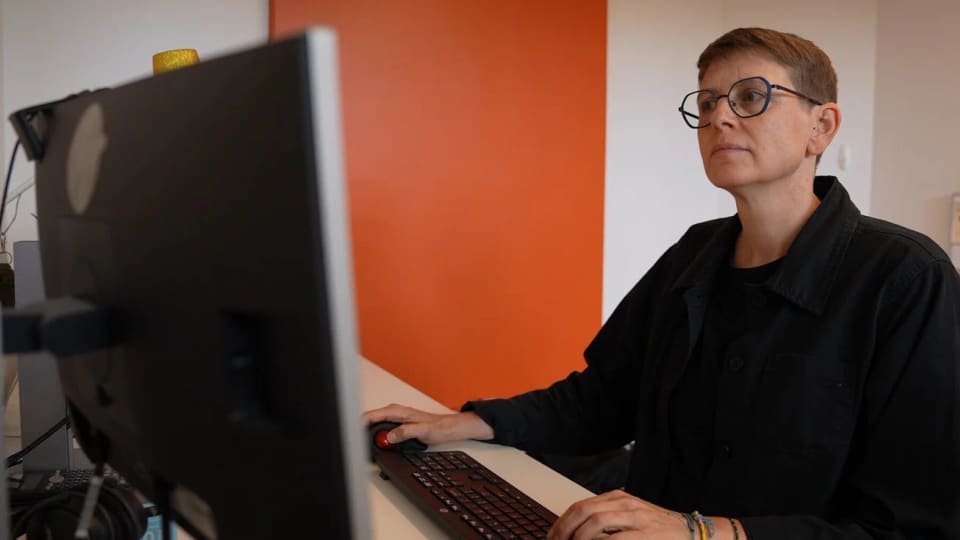 Stephanie Dixon working at a desktop computer in an office.